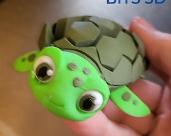 May include: A 3D-printed green turtle figurine with a smiling face and large eyes. The turtle's shell is a darker green, and the text "Pre-Clean up" is visible below the turtle. The logo "BITS 3D" is in the background.