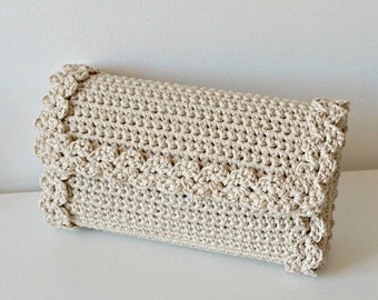 May include: A beige crocheted clutch bag with a scalloped edge.