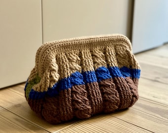 May include: A crocheted bag with brown, beige, blue, and green stripes. The bag is made with a cable stitch pattern.