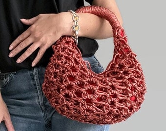 May include: A red crocheted handbag with a silver chain handle.
