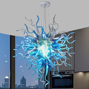 May include: A large, spherical chandelier composed of numerous hand-blown glass tentacles in shades of translucent blue, light blue, and clear glass. The fixture is suspended from a circular white ceiling mount by thin, metallic wires.