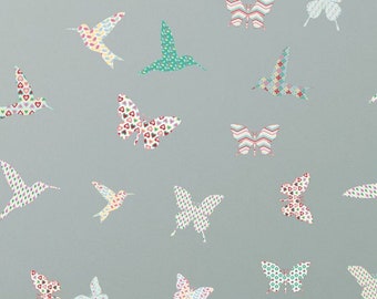 May include: A wall decorated with colourful butterfly and hummingbird wall decals. The decals are made of patterned paper and feature a variety of colours and designs. The decals are arranged in a random pattern on a light blue wall.
