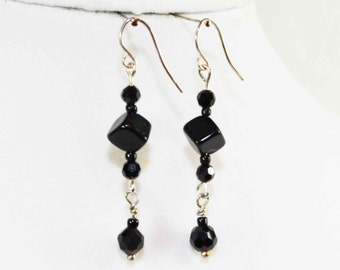 May include: Black dangle earrings with faceted black beads and a square black stone.