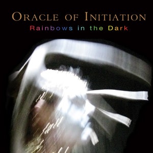 Op de afbeelding: Een boekomslag met de titel "Oracle of Initiation: Rainbows in the Dark" en de naam van de auteur "Melissae Lucia". De omslag toont een wazig beeld van een persoon in een witte kleding met een regenboog-effect.