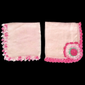 May include: Two pink handkerchiefs with pink and white crocheted lace trim. One handkerchief has a pink crocheted flower with a green centre.