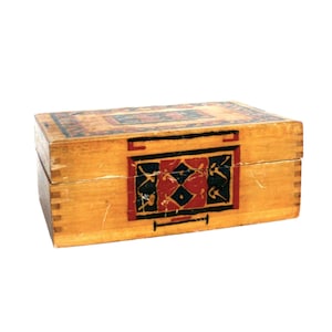 May include: A wooden box with a painted design on the lid and front. The design features geometric shapes in red, blue, and black on a yellow background.