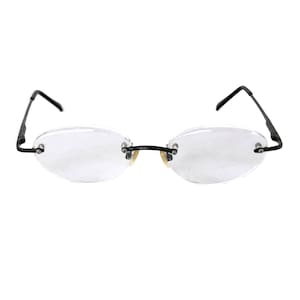May include: Rimless eyeglasses with oval lenses and black metal arms. The nose bridge is a light gold color. The glasses have a minimalist design, suitable for everyday wear.