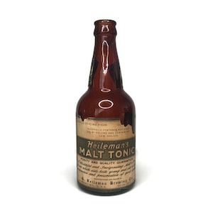 May include: A brown glass bottle with a label that reads "Heileman's Malt Tonic". The label also states "Purity and Quality Guaranteed" and includes the text "Manufactured and Packed by G. Heileman Brewing Co. La Crosse, Wis. U.S.A."