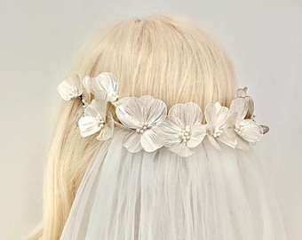 Velo de novia con tocado floral: Velo drapeado estilo bohemio con flores metálicas.