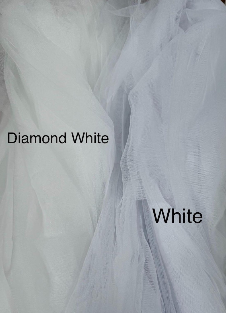 May include: Two layers of sheer, fine-mesh tulle fabric displayed side-by-side. The left section is labeled Diamond White, and the right section is labeled White. The fabric has a soft, translucent texture with visible folds and gathers.