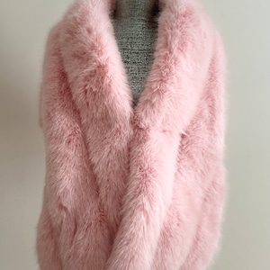 May include: A pink faux fur stole with a wide collar. The stole is made of soft, fluffy fur and is perfect for adding a touch of luxury to any outfit.