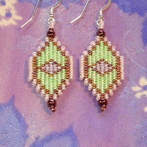 May include: A pair of green, brown, and white beaded earrings with silver hooks. The earrings are shaped like a diamond and have a geometric pattern.