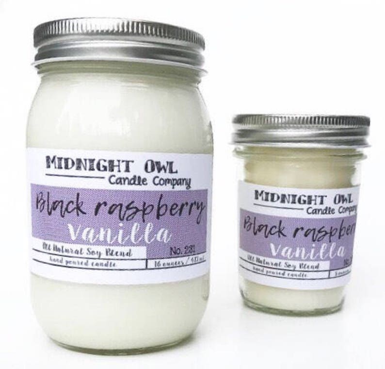 May include: Two glass jars with silver lids containing candles. The labels on the jars read "Midnight Owl Candle Company" and "Black Raspberry Vanilla". The larger jar is 16 ounces and the smaller jar is 8 ounces.