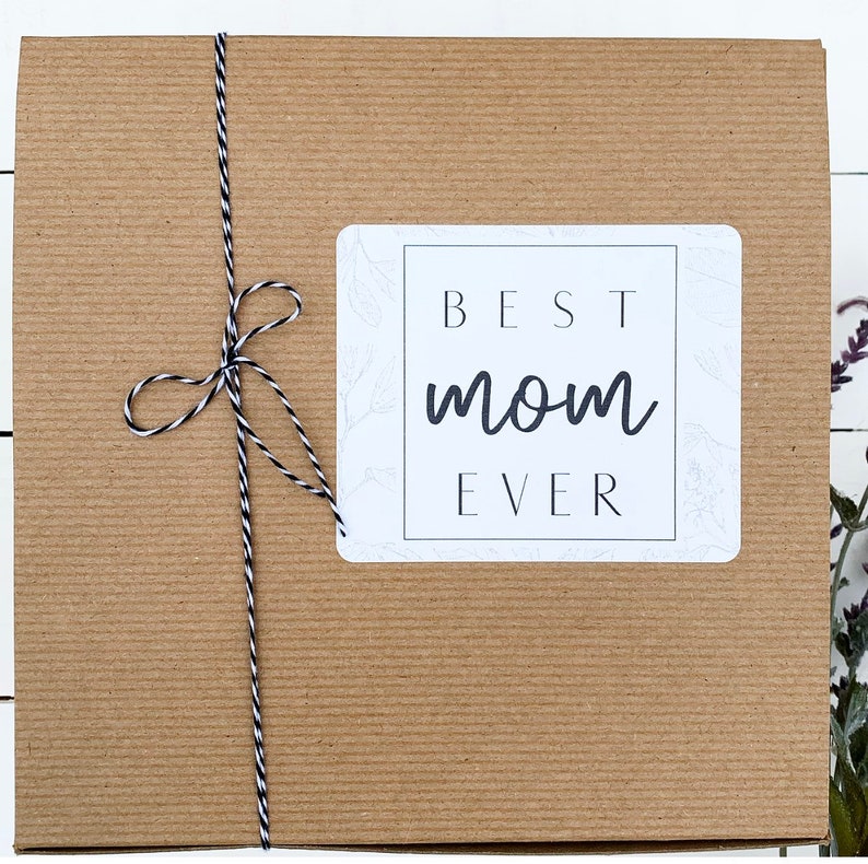 May include: A brown cardboard box with a white label that says "BEST mom EVER". The box is tied with a black and white twine.