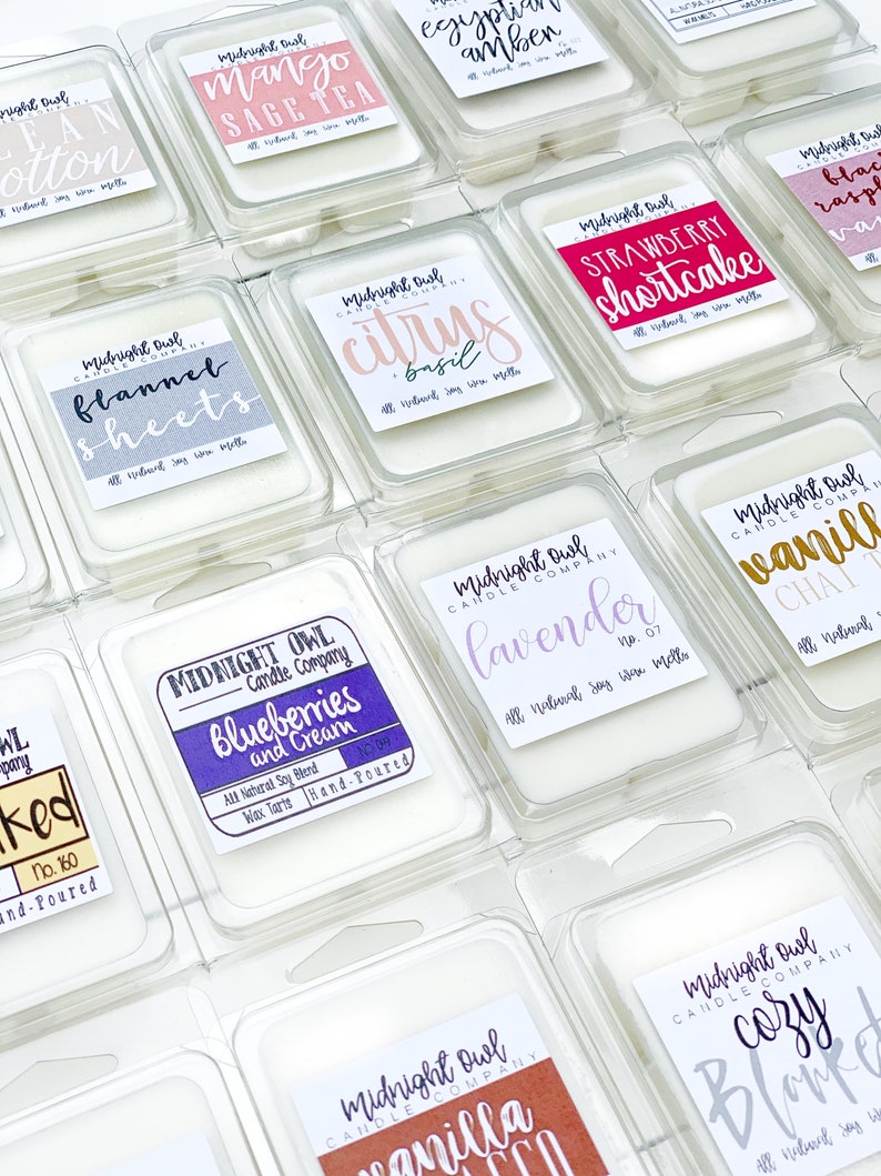 Puede incluir: Surtido de peque&ntilde;os recipientes de cera para fundir transparentes con etiquetas que presentan varios aromas, incluyendo "S&aacute;banas de franela", "T&eacute; de mango y salvia", "Ar&aacute;ndanos y crema", "Chai de vainilla", "Manta acogedora", "Pastel de fresa", "Lavanda", "Albahaca c&iacute;trica" y "&Aacute;mbar egipcio".