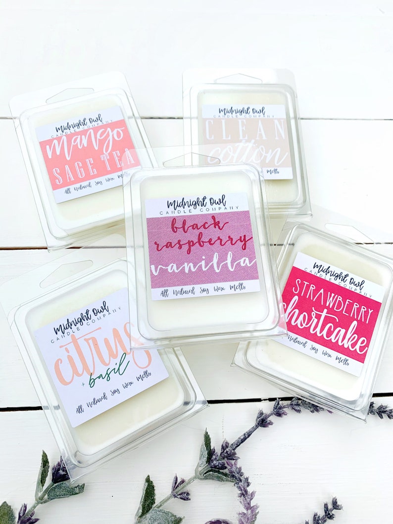 Puede incluir: Cinco fundidos de cera en recipientes de pl&aacute;stico transparente con etiquetas. Las etiquetas son de color rosa, rojo y blanco con texto que dice "Midnight Owl Candle Company" y varios aromas, que incluyen "Mango Sage Tea", "Clean Cotton", "Black Raspberry Vanilla", "Citrus & Basil" y "Strawberry Shortcake".