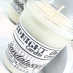 May include: A glass jar candle with a white label that reads "Midnight Candle Company Vanilla & Sandalwood". The candle is hand-poured with a natural soy blend and is 4 oz (123 ml).