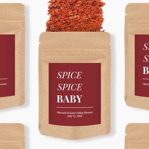 May include: A brown kraft paper pouch filled with red chili flakes. The pouch features a dark red label with white text that reads: SPICE SPICE BABY, Hannah & Juan's Baby Shower, July 11, 2024. The design is repeated in a pattern across the image.