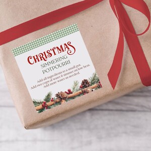 May include: A brown paper-wrapped gift tied with a red ribbon. The label reads "Christmas Simmering Potpourri" and includes instructions. The label is decorated with pine cones, cinnamon sticks, and berries.