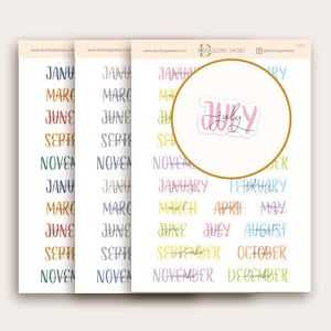 May include: A set of colorful monthly planner stickers with handwritten font. The stickers are in various colors, including yellow, orange, pink, blue, and green. The stickers feature the months of the year, including January, February, March, April, May, June, July, August, September, October, November, and December.