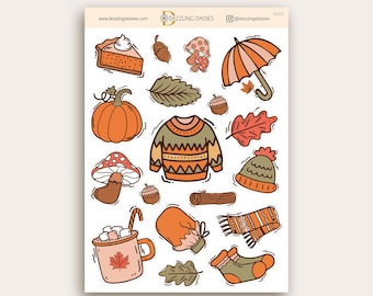 May include: Sheet of fall-themed stickers featuring illustrations of a pumpkin, sweater, pie, mushrooms, acorns, leaves, umbrella, mittens, scarf, hat, socks, and a mug of hot cocoa. The stickers are in shades of orange, brown, and green.