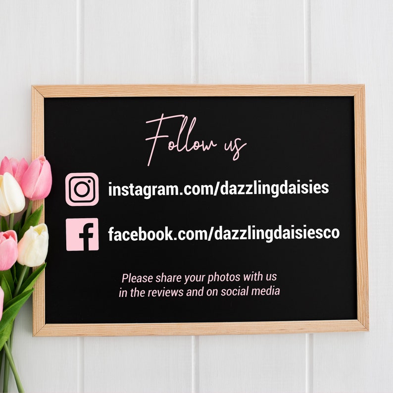 May include: Black chalkboard with white wooden frame, displaying social media handles for "dazzlingdaisies" on Instagram and Facebook. The text "Follow us" is written in pink cursive above the handles. The text "Please share your photos with us in the reviews and on social media" is written in white below the handles.