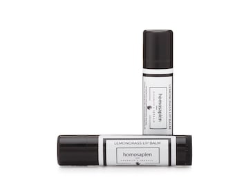 May include: Two black tubes of lemongrass lip balm with the brand name "homosapien" and the text "ORGANICS & HERBALS" on the label.