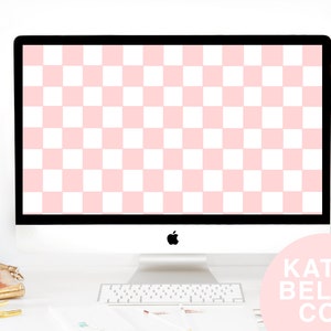 May include: A pink and white checkered desktop background displayed on a silver iMac computer. The computer is on a white desk with a gold tray and pens. The text "KATIE BELLE CO." is displayed in white on a pink circle.