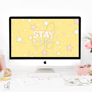 May include: A yellow desktop background with white and pink stars and the text "STAY positive" in a pink and white outline. The background is displayed on a white iMac computer.