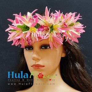 May include: A pink and white flower lei with green leaves. The lei is made of silk flowers and is worn on a mannequin's head. The lei is a traditional Hawaiian flower garland.