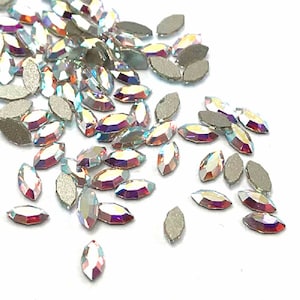 May include: A scattering of iridescent marquise-shaped rhinestones, perfect for crafting and embellishing projects.