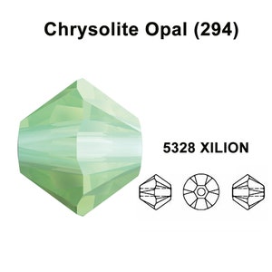 Könnte beinhalten: Eine einzelne, facettierte Kristallperle in hellgrün mit einem 5328 Xilion-Schliff. Die Perle ist in der Farbe Chrysolite Opal.