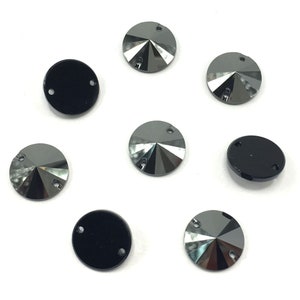 Op de afbeelding: Acht ronde zwarte en zilveren strass steentjes met elk twee gaten. De strass steentjes hebben een facetgeslepen ontwerp.