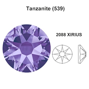 Pode incluir: Close-up de um cristal de Tanzanite (539) roxo, um Xirius 2088, com um padrão de faceta em forma de estrela. O cristal é redondo e tem um alto brilho.