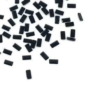 以下が含まれることがあります： 白い背景に散らばった小さな黒い長方形のラインストーン