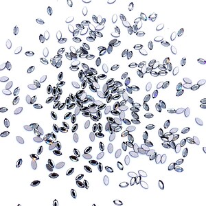 Peut inclure: Plusieurs strass argentés en forme de navette sont dispersés sur un fond blanc. Ces petits ornements réfléchissants sont disposés de manière aléatoire, créant un effet scintillant. Idéal pour le nail art, l'artisanat ou pour ajouter de l'éclat.