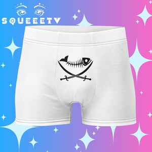 Puede incluir: Bóxers blancos con un gráfico negro de una espina de pescado y espadas cruzadas. La palabra "SQUEEETV" está impresa en la parte superior. La ropa interior tiene un ajuste cómodo y un diseño clásico.