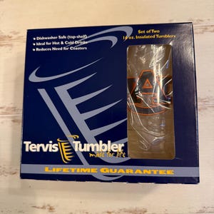 Puede incluir: Una caja azul marino con dos vasos aislados Tervis de 473 ml. La caja tiene el texto "Tervis Tumbler" y "Garantía de por vida". Los vasos son aptos para lavavajillas e ideales para bebidas frías y calientes.