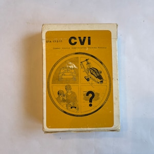 May include: A deck of cards titled "CVI" with the text "Combat Vehicle Identification Training Program." The card's face features a circular design with illustrations of military vehicles and personnel, including a tank, helicopter, and soldiers. The background is a mustard yellow color.