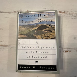 Può includere: Un libro intitolato "Blasted Heaths and Blessed Greens" con un'immagine di un campo da golf. Il sottotitolo del libro è "A Golfer's Pilgrimage to the Courses of Scotland" di James W. Finegan.