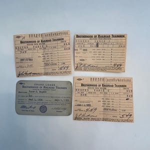 May include: Four vintage Brotherhood of Railroad Trainmen documents and a membership card. The documents are tan with black text, featuring names, dates, and financial details. The membership card is gray with blue text and a circular emblem.