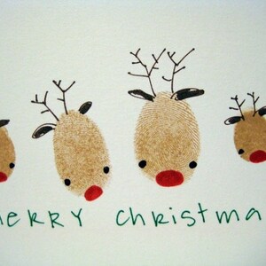 May include: A white card with four brown reindeer drawn with fingerprints. The reindeer have black eyes and red noses. The card says "merry christmas" in green letters.