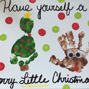 May include: A white canvas with the text "Have yourself a Merry Little Christmas" written in black marker. A green handprint tree with red dots and a yellow star on top is on the left side of the canvas. A brown handprint reindeer with googly eyes is on the right side of the canvas. The canvas is decorated with red and green dots.
