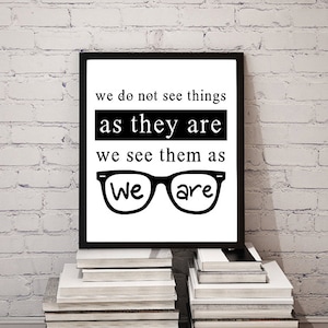 May include: Black and white typography print with the quote "we do not see things as they are we see them as We are" with a pair of glasses drawn in between the last two lines.