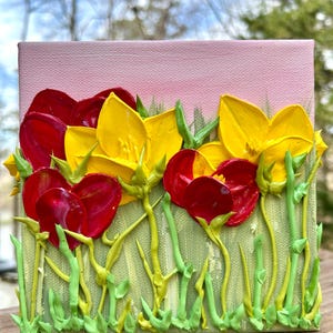 May include: A textured painting of vibrant flowers. The artwork features red and yellow blooms with green stems and leaves against a light green and pink background. The flowers are painted with thick brushstrokes, creating a 3D effect.