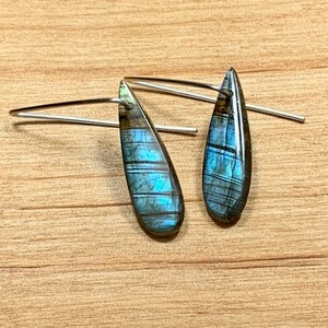 May include: A pair of silver teardrop earrings with iridescent blue labradorite stones.