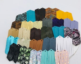 Peut inclure: Assortiment de 24 breloques de boucles d'oreilles en cuir à franges de différentes couleurs et motifs, notamment turquoise, or, marron, noir, blanc et rose.