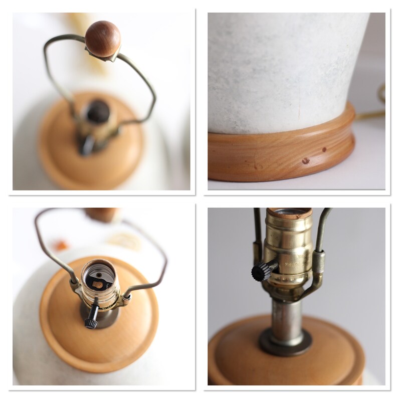 May include: Close-up of a white ceramic lamp base with a wooden base. The lamp has a brass socket and a black switch. The lamp is in the off position.
