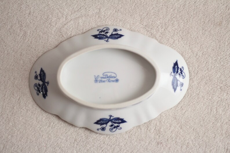 May include: White oval ceramic dish with blue floral designs and the text "V. Madeleines Blue China" on the bottom.
