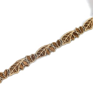 May include: Brown and gold leaf-shaped trim with a delicate, intricate design. This trim is perfect for adding a touch of elegance to any project.